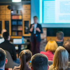 Amtivo (Formerly Certification Europe and EQA) - ISO 22301 Business Continuity Workshop - Someone in a suit speaking at a workshop to a class of learners