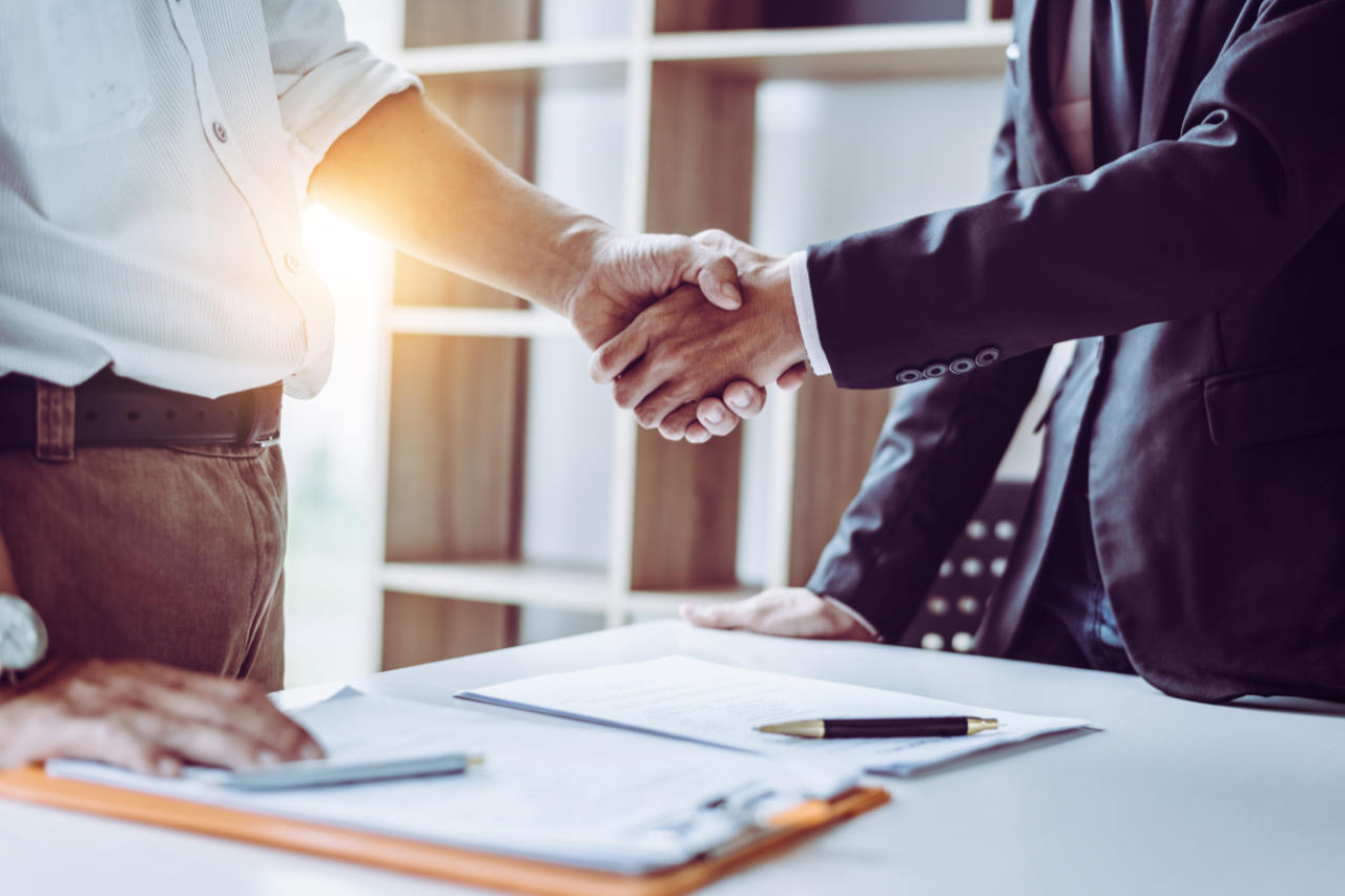 Business people shaking hands as a benefit of ISO certification